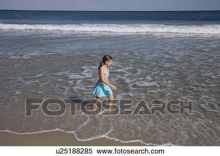 Girl walking in ocean surf View Large Photo Image Stock Photography - Girl walking in ocean surf. Fotosearch