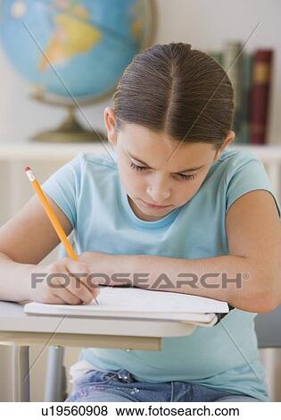 Stock Photo - Girl writing in classroom. Fotosearch