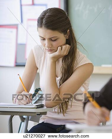 Girl writing in classroom View Large Photo Image Stock Photo - Girl writing in classroom. Fotosearch