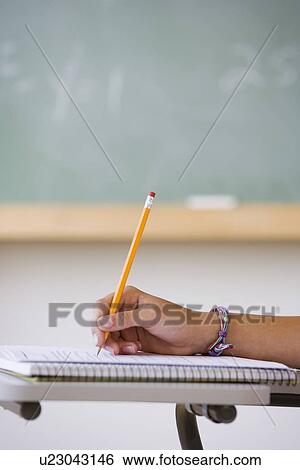 Stock Photograph - Girl writing in classroom. Fotosearch