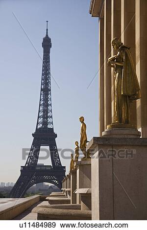 Stock Photo - Golden statues with Eiffel Tower in background. Fotosearch