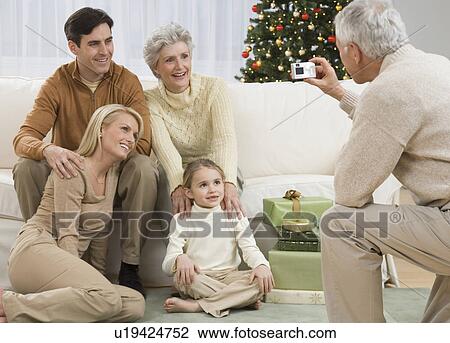 Grandfather taking photograph of family on Christmas View Large Photo Image Stock Image - Grandfather taking photograph of family on Christmas. Fotosearch