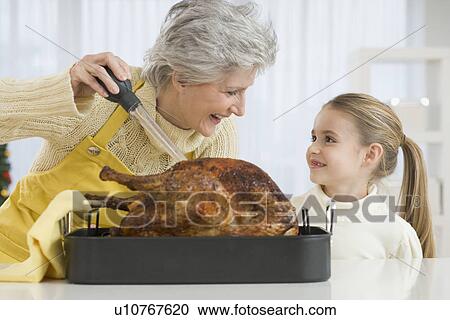 Grandmother and daughter basting roast turkey View Large Photo Image Stock Image - Grandmother and daughter basting roast turkey. Fotosearch
