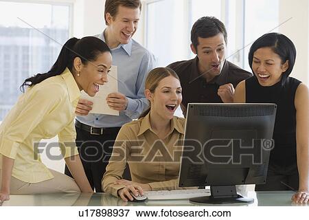 Stock Photo - Group of businesspeople looking at computer. Fotosearch
