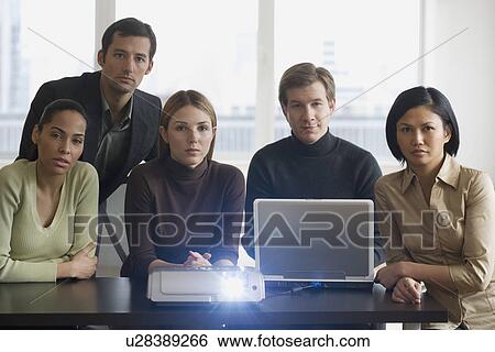 Stock Photograph - Group of businesspeople using projector at meeting. Fotosearch