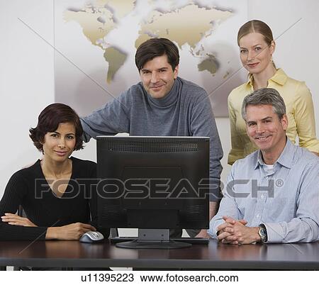 Stock Image - Group of businesspeople with computer. Fotosearch