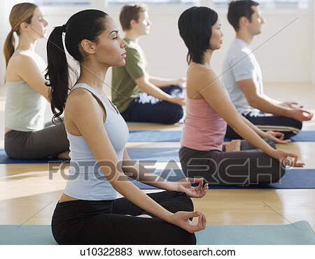 Stock Image - Group of people practicing yoga. Fotosearch