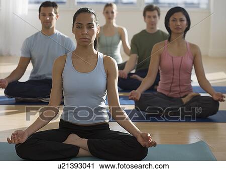 Stock Image - Group of people practicing yoga. Fotosearch