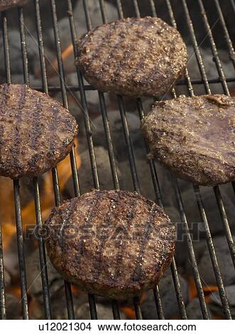 Picture - Hamburgers cooking on grill. Fotosearch