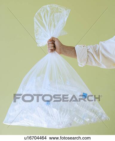 Hand holding bag of empty water bottles View Large Photo Image Picture - Hand holding bag of empty water bottles. Fotosearch