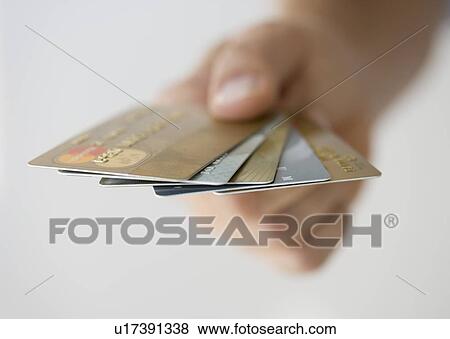 Stock Photo - Hand holding fanned out credit cards. Fotosearch