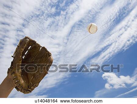 Picture - Hand in baseball glove catching ball. Fotosearch