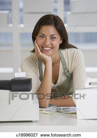 Stock Photo - Hispanic bakery worker behind counter. Fotosearch