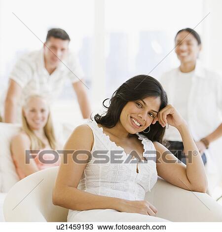 Stock Image - Hispanic woman in front of friends. Fotosearch