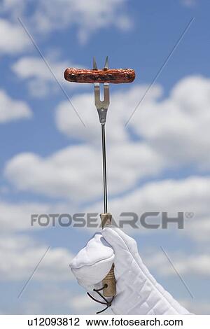 Stock Image - Hot dog on barbeque fork. Fotosearch