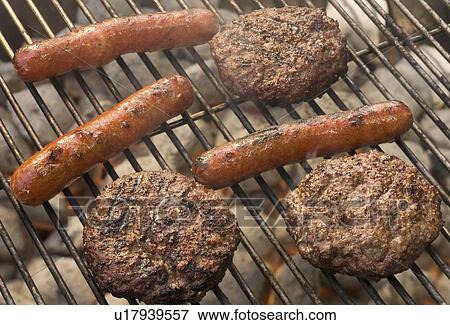 Hot dogs and hamburgers cooking on grill View Large Photo Image Stock Photo - Hot dogs and hamburgers cooking on grill. Fotosearch