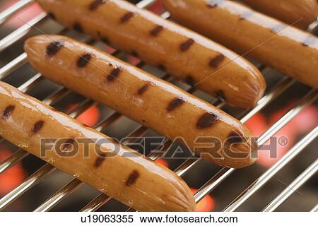 Stock Photography - Hot dogs cooking on grill. Fotosearch
