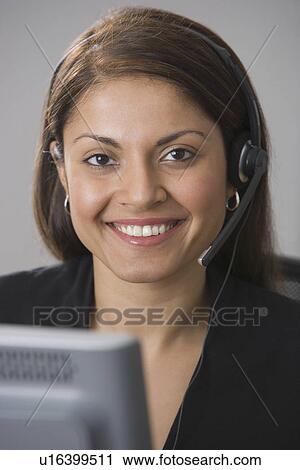 Stock Image - Indian businesswoman wearing headset. Fotosearch