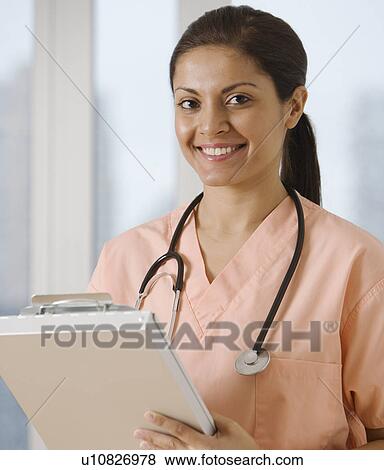 Indian female doctor writing on chart View Large Photo Image Stock Photo - Indian female doctor writing on chart. Fotosearch