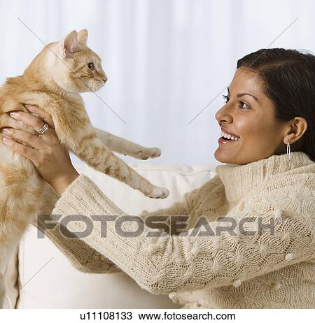 Stock Image - Indian woman holding cat. Fotosearch