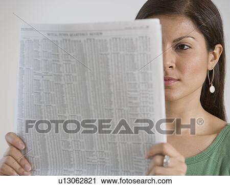 Stock Image - Indian woman reading newspaper. Fotosearch