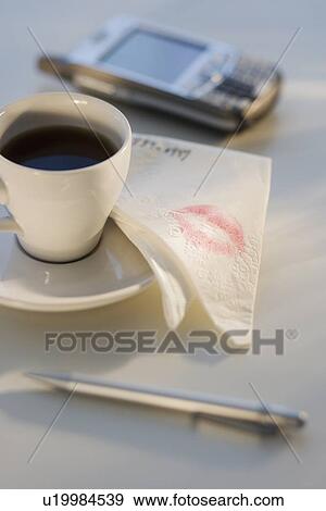 Stock Photo - Lipstick on napkin next to coffee. Fotosearch