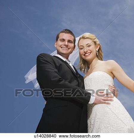 Low angle view of bride and groom View Large Photo Image Stock Image - Low angle view of bride and groom. Fotosearch