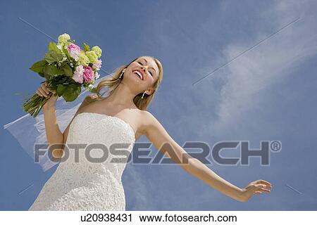 Stock Image - Low angle view of bride. Fotosearch