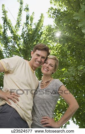 Stock Photo - Low angle view of couple hugging. Fotosearch