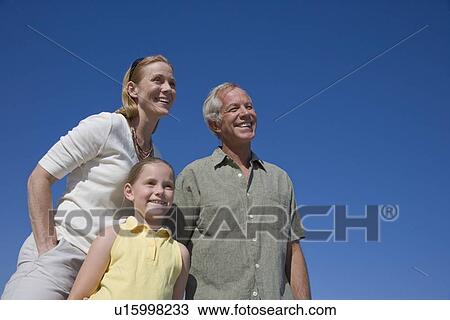 Low angle view of family under blue sky View Large Photo Image Stock Image - Low angle view of family under blue sky. Fotosearch