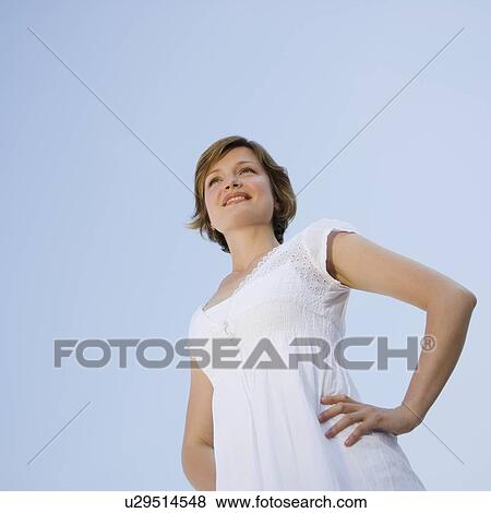 Low angle view of woman with hands on hips View Large Photo Image Stock Photo - Low angle view of woman with hands on hips. Fotosearch