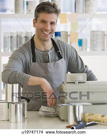 Picture - Male clerk at counter of paint store. Fotosearch