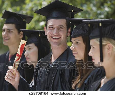 Picture - Male college graduate holding diploma. Fotosearch