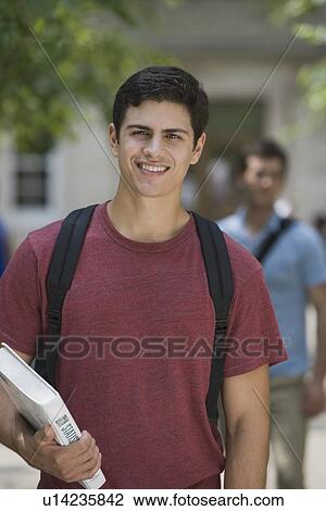 Male college student holding book View Large Photo Image Stock Image - Male college student holding book. Fotosearch