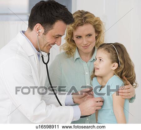 Stock Image - Male doctor listening to girl’s heart. Fotosearch