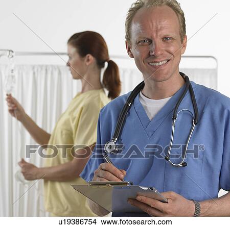 Male doctor smiling and holding chart View Large Photo Image Picture - Male doctor smiling and holding chart. Fotosearch