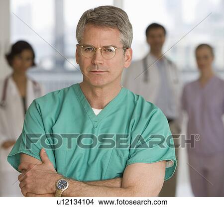 Picture - Male doctor wearing scrubs. Fotosearch