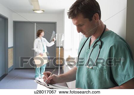 Male doctor writing on chart View Large Photo Image Stock Photo - Male doctor writing on chart. Fotosearch