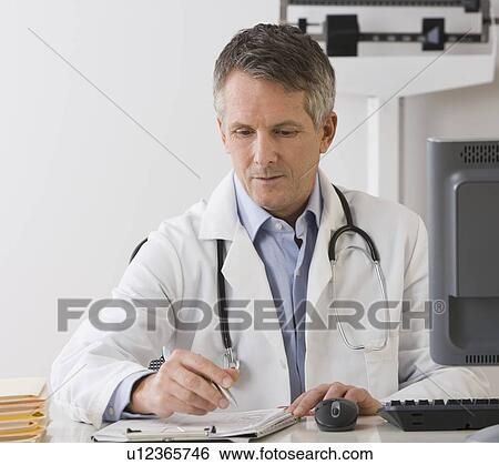 Stock Photograph - Male doctor writing on chart. Fotosearch