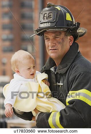 Male firefighter carrying baby View Large Photo Image Stock Image - Male firefighter carrying baby. Fotosearch