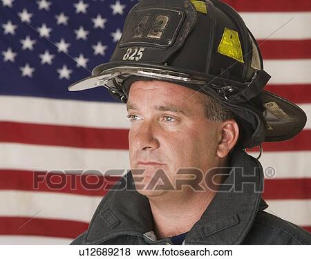 Male firefighter in front of American flag View Large Photo Image Stock Photo - Male firefighter in front of American flag. Fotosearch