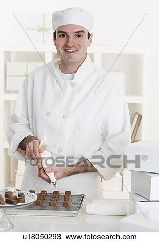 Stock Image - Male pastry chef in kitchen. Fotosearch