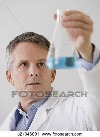 Male scientist looking at beaker View Large Photo Image Stock Image - Male scientist looking at beaker. Fotosearch