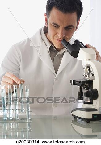 Male scientist looking at vials View Large Photo Image Picture - Male scientist looking at vials. Fotosearch