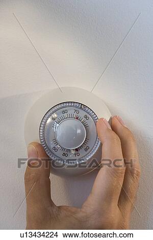 Man adjusting thermostat View Large Photo Image Picture - Man adjusting thermostat. Fotosearch