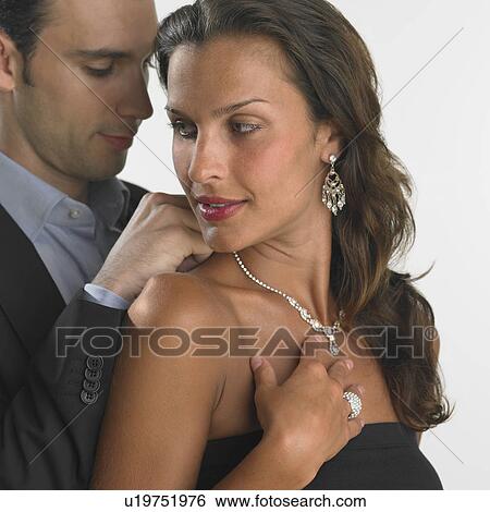 Stock Photograph - Man clasping woman's necklace for her. Fotosearch