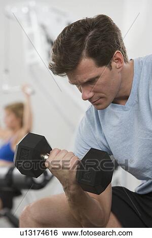 Man exercising with weight View Large Photo Image Stock Photograph - Man exercising with weight. Fotosearch