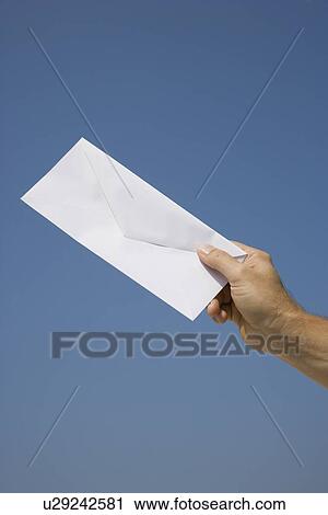 Stock Image - Man holding envelope. Fotosearch