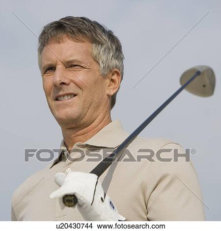 Man holding golf club on shoulder View Large Photo Image Picture - Man holding golf club on shoulder. Fotosearch