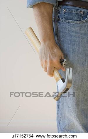 Man holding hammer and nails View Large Photo Image Picture - Man holding hammer and nails. Fotosearch
